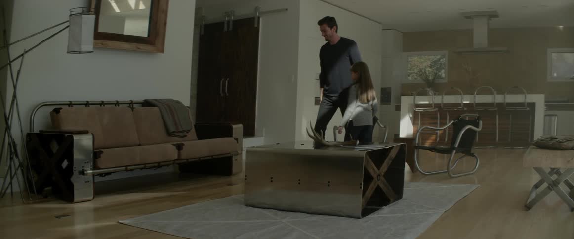 A man walks into a room and hugs a girl then sits with her