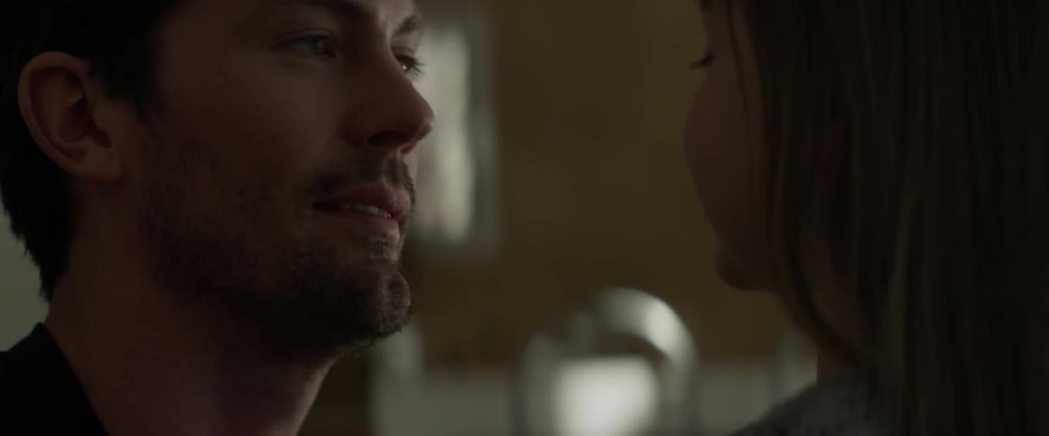 Father and daughter talking in a dark area indoors