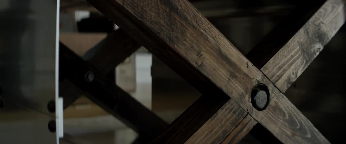 A person walking by is reflected on the stainless sides of a table
