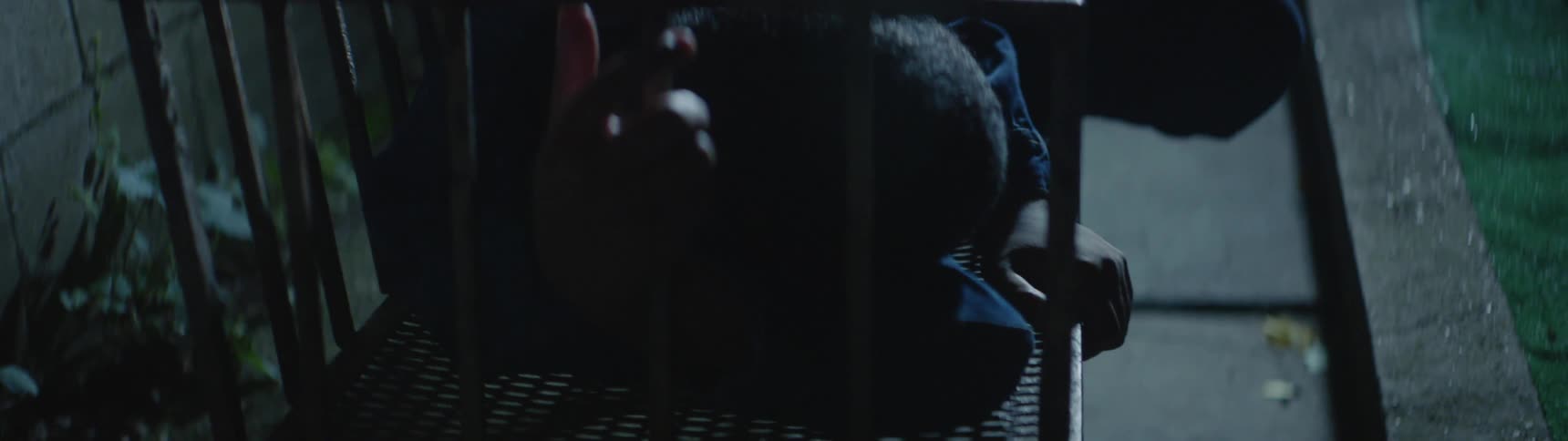 A boy lies on a metal bench