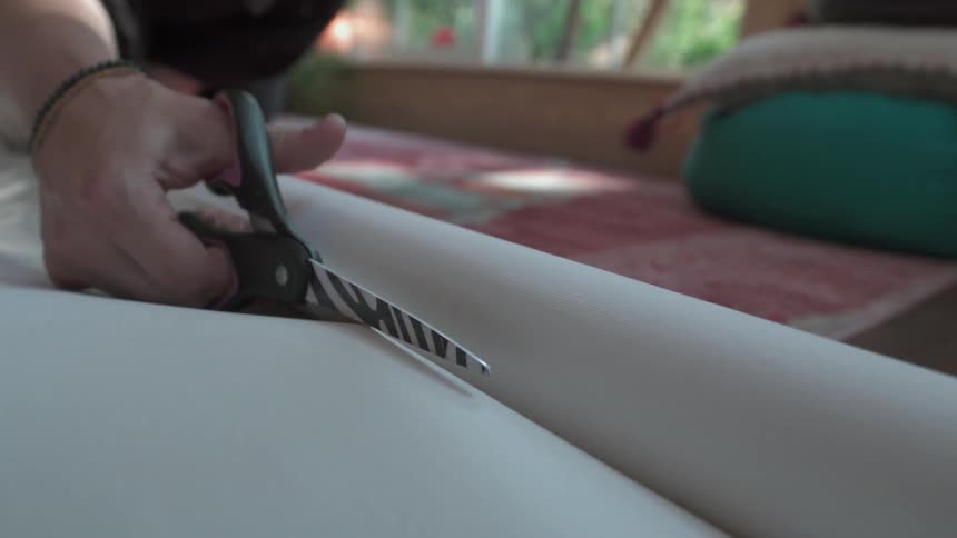A person cuts paper from a roll