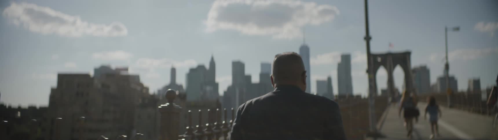 A man walks near a metal fence
