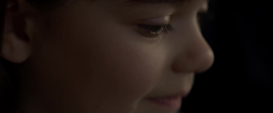 A girl smiles as she looks at something