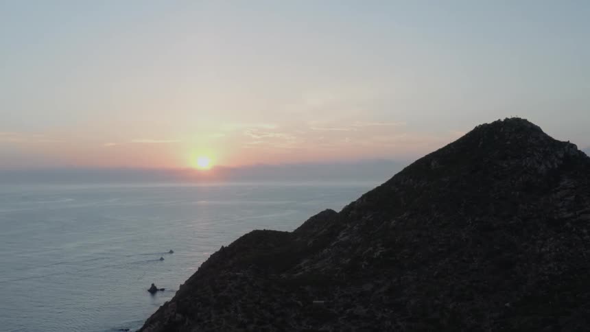 The sun sets on the horizon over the ocean