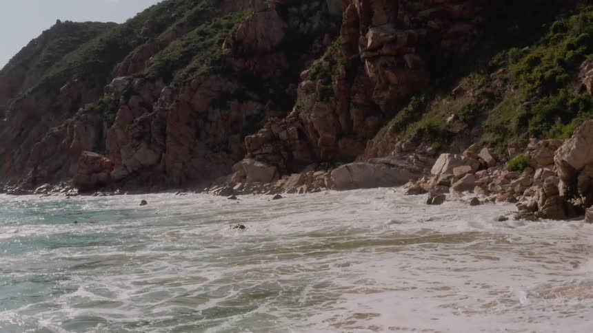 Ocean waves crash against the rocks on shore