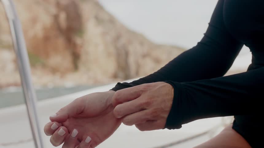 Woman adjusting her sleeves onto her hands while sitting on a boat