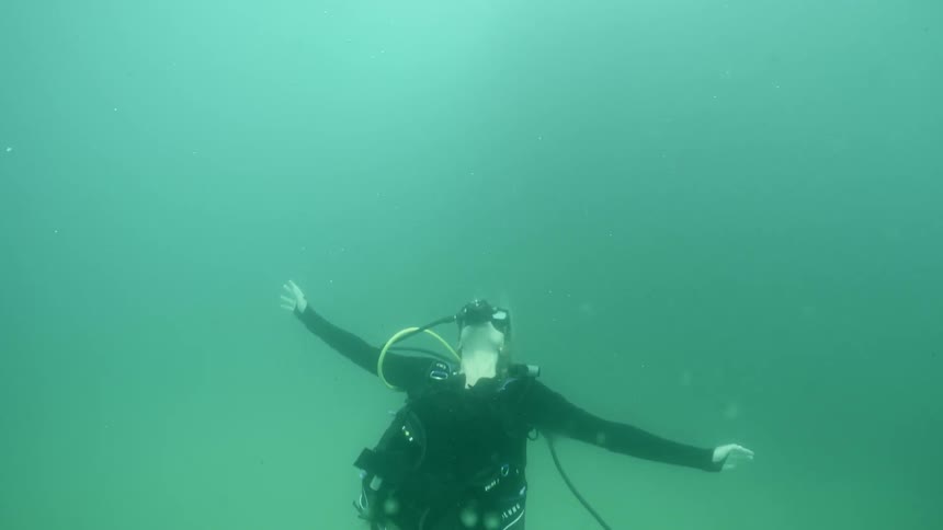 A diver is swimming and summer-salting in the ocean