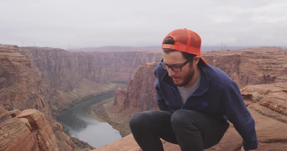 A person looking at a river that runs thru a canyon