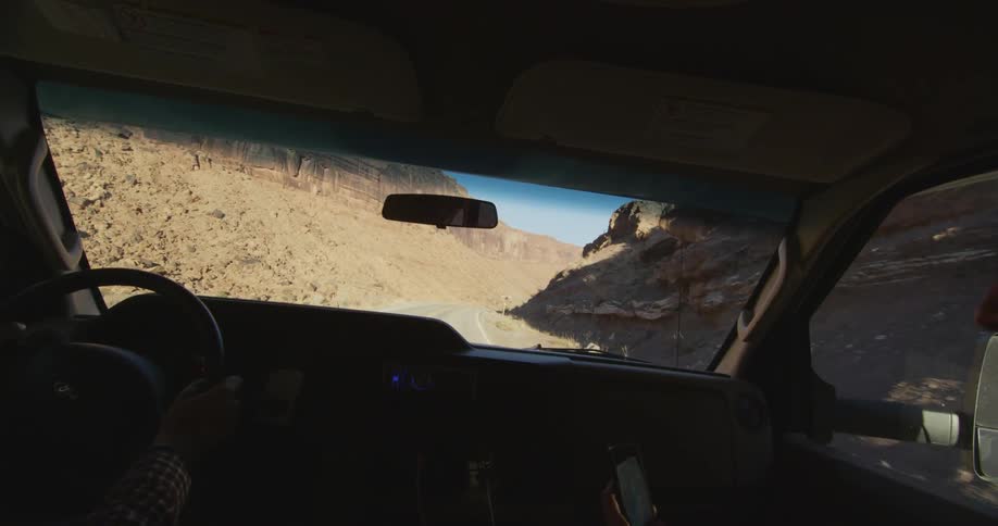 View out the windshield of a vehicle driving down a desolate highway