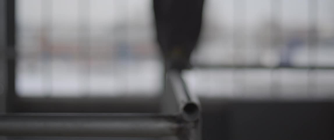 A person walks and balances on a metal pipe