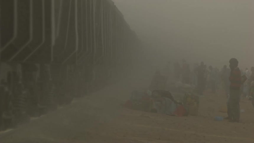 A train is going by a group of people in the desert