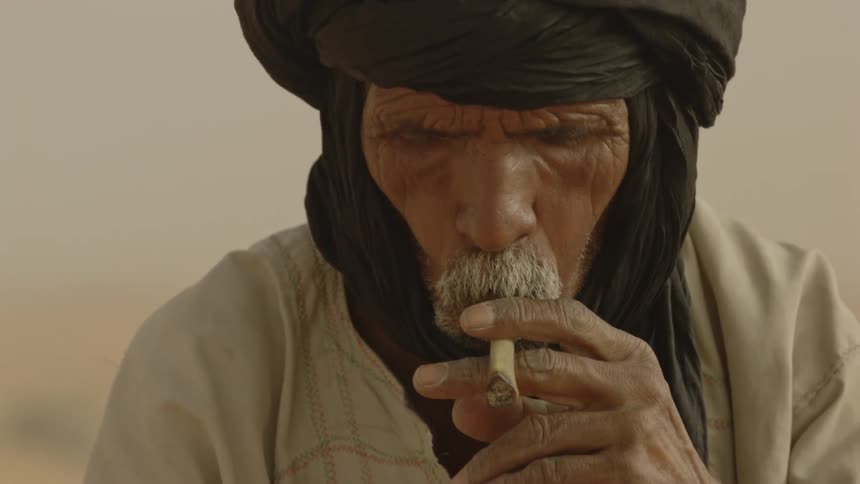 Man smokes a cigarette in a desert