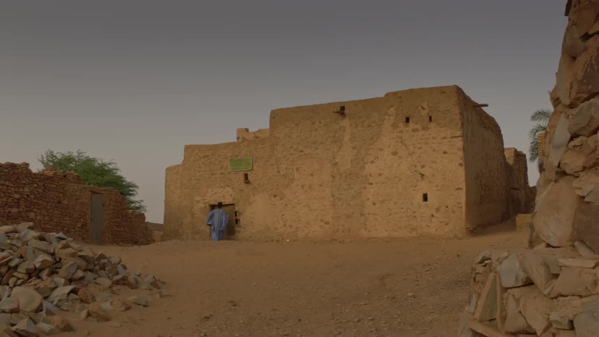 A man approaches a desert home