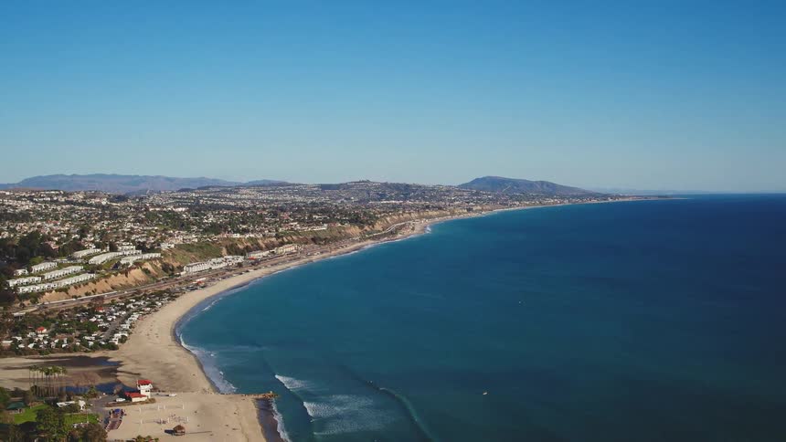 Ocean waves come to shore on the beaches of a coastal city