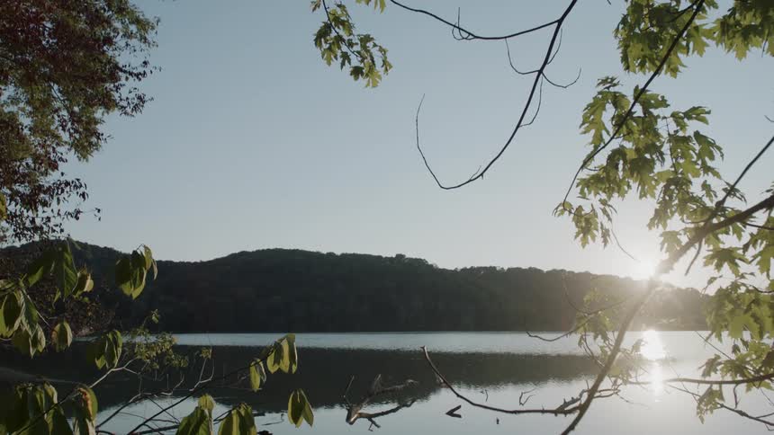 A lake at the base of a forested mountain