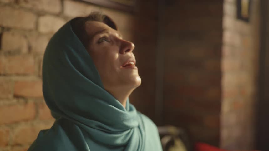 A woman shakes her head and looks up