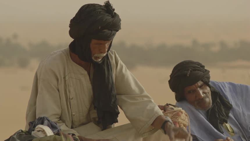 A man pours tea in the desert