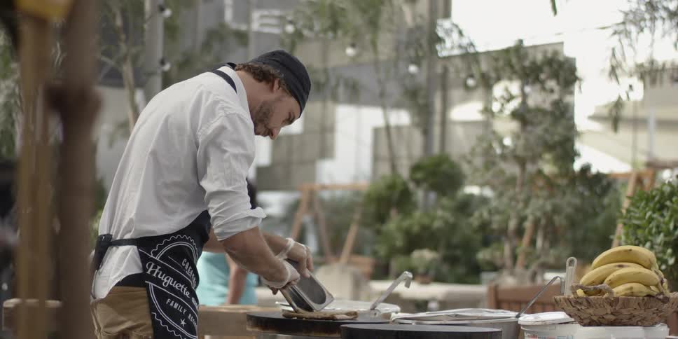 A chef stirs food at a buffet