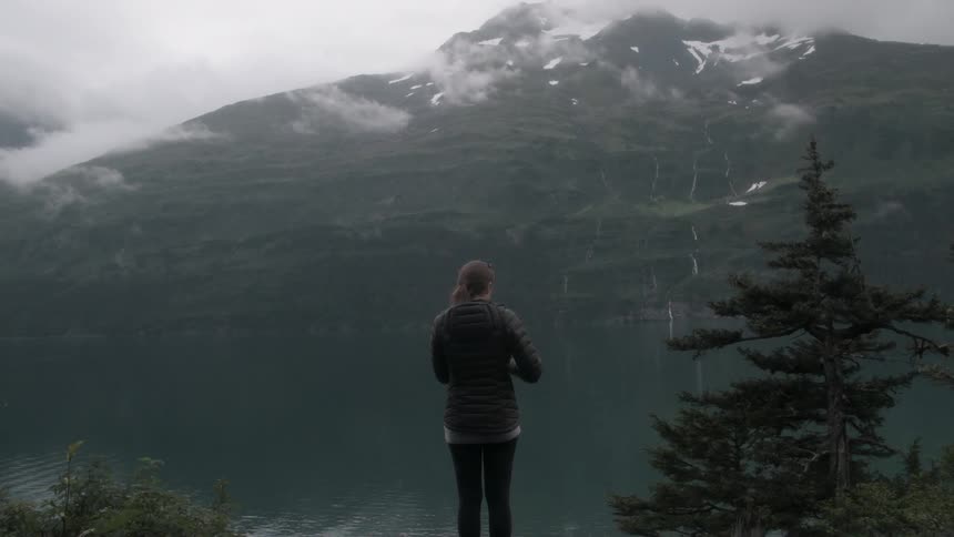 A woman takes some photos of a mountain view
