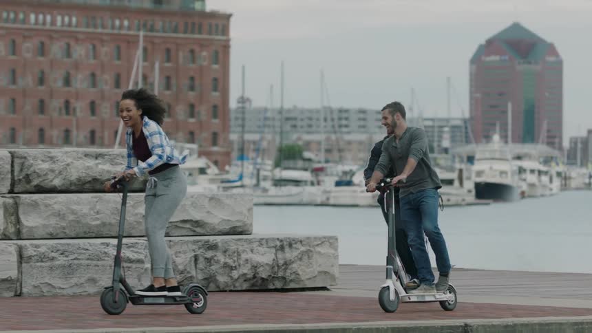 People ride their scooters around the corner