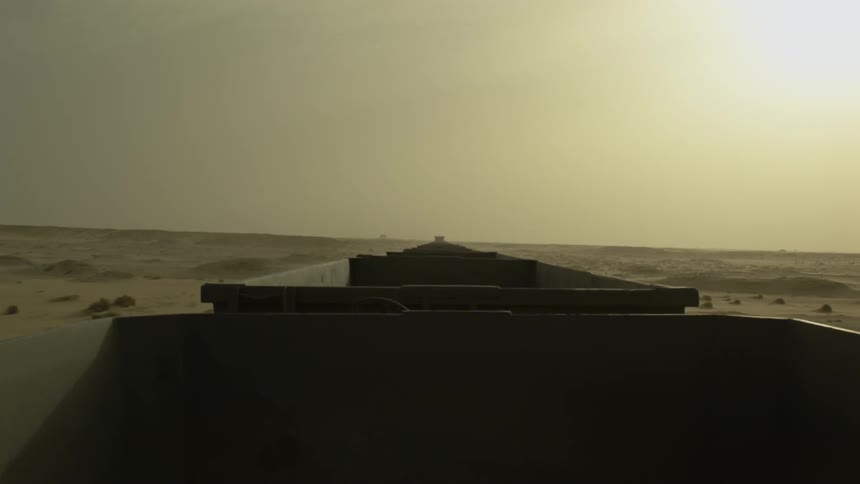 A train travels through a desert at sunset