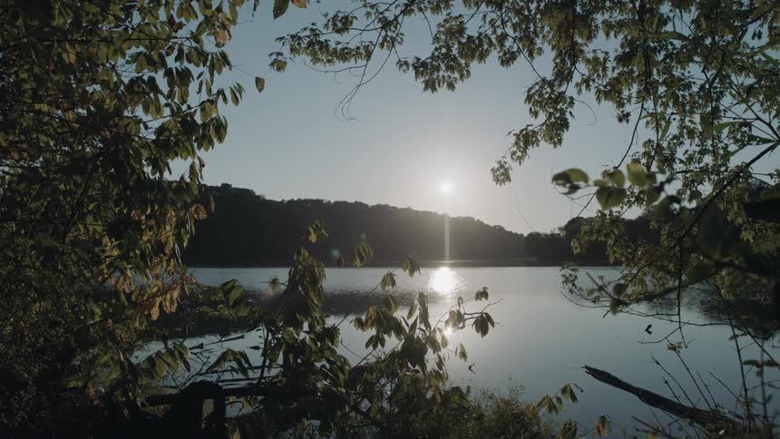 The sun shines over a mountain lake