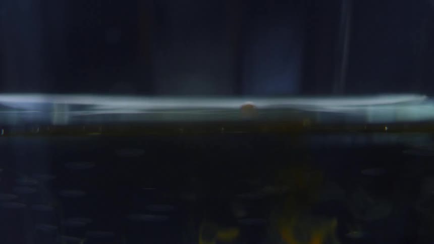 Yellow liquid drips into water