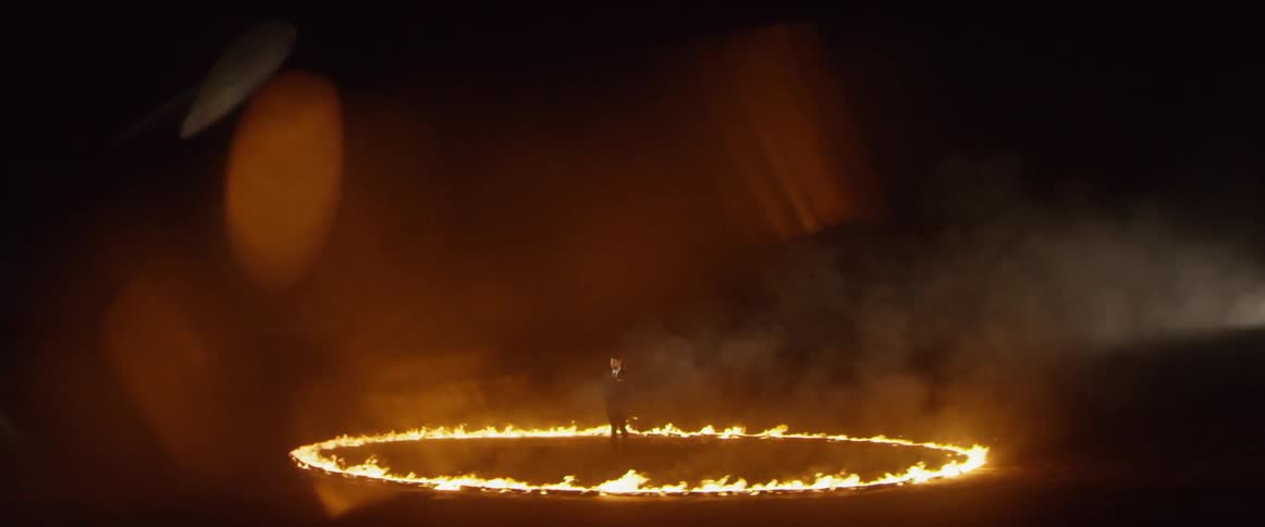 A man stands in the middle of a large ring of fire