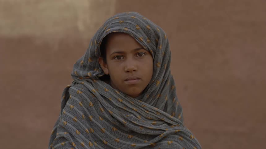A girl is standing outside on a windy day