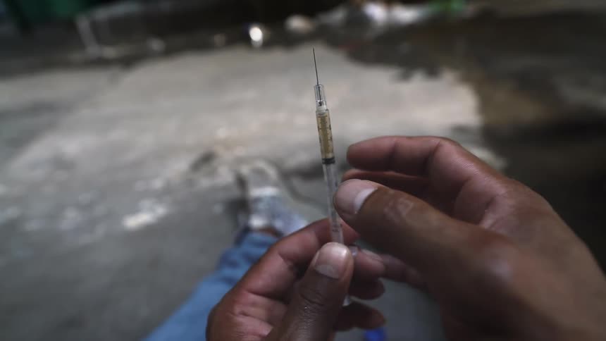 A person flicks a needle in his hand