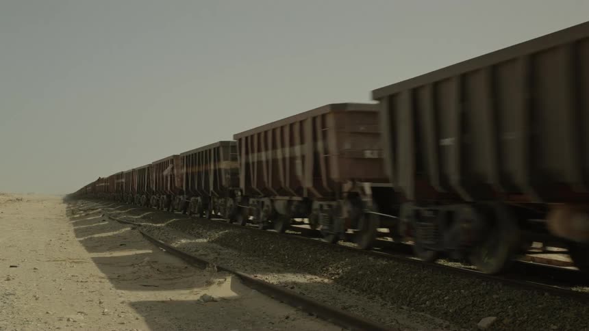 The train moves fast down the desert tracks
