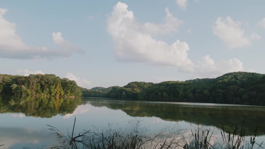A lake is reflecting its surrounding on a cloudy day
