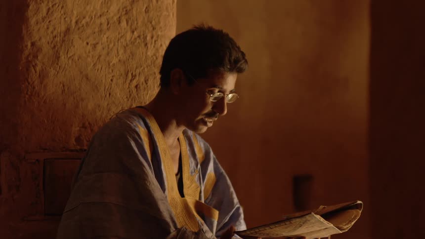 A man in a robe is reading a book
