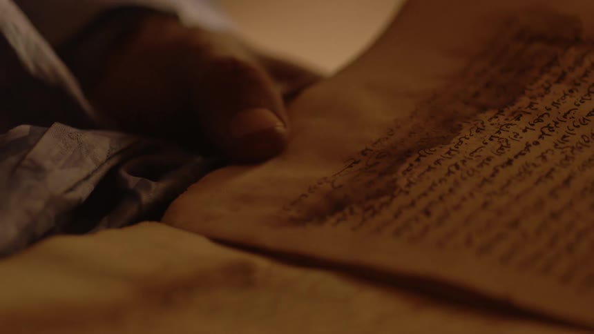 Someone is holding a very old book