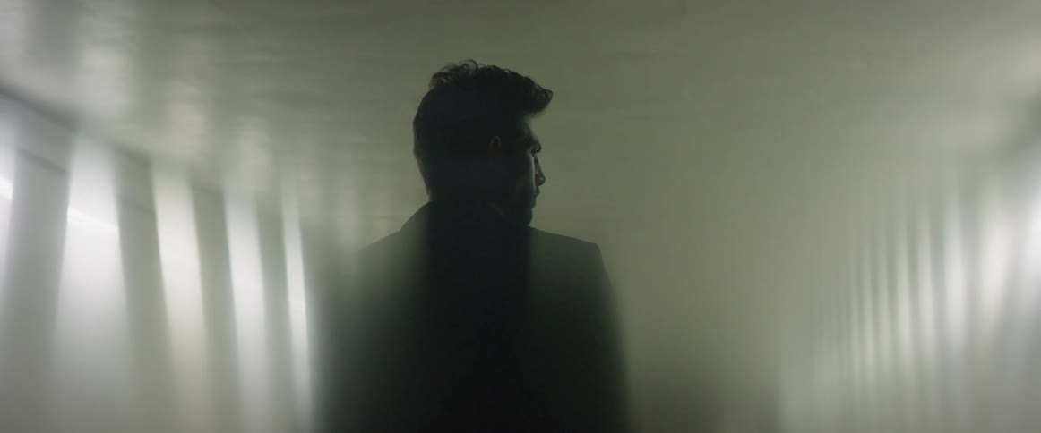 A man is walking in the dark hall
