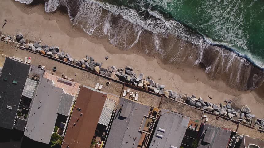 Waves flow onto the beach shore by buildings