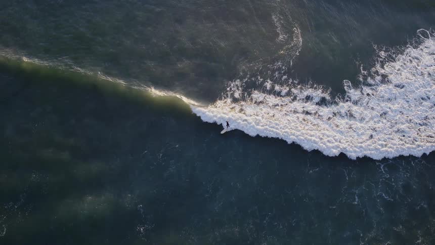 A surfer rides an ocean wave