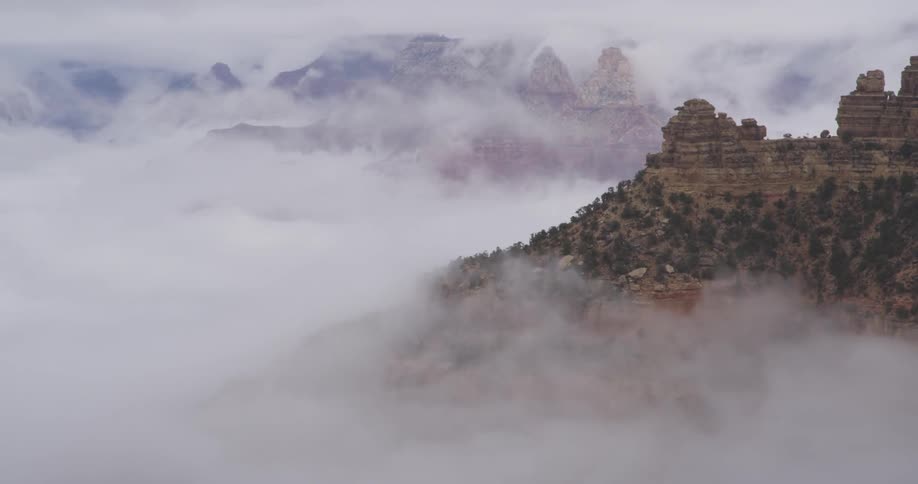 Clouds form and billow around a mountain