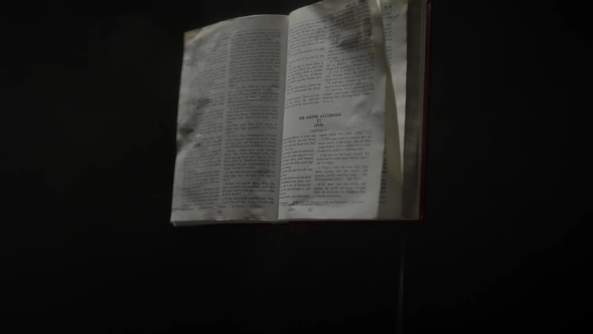 A page of an open book is blown around