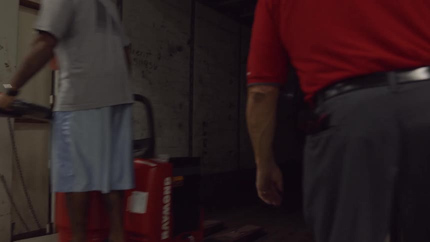 A man is riding a forklift through a factory