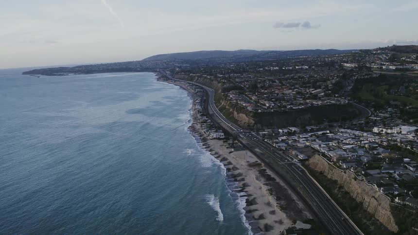 The town by the beach has many cars driving past