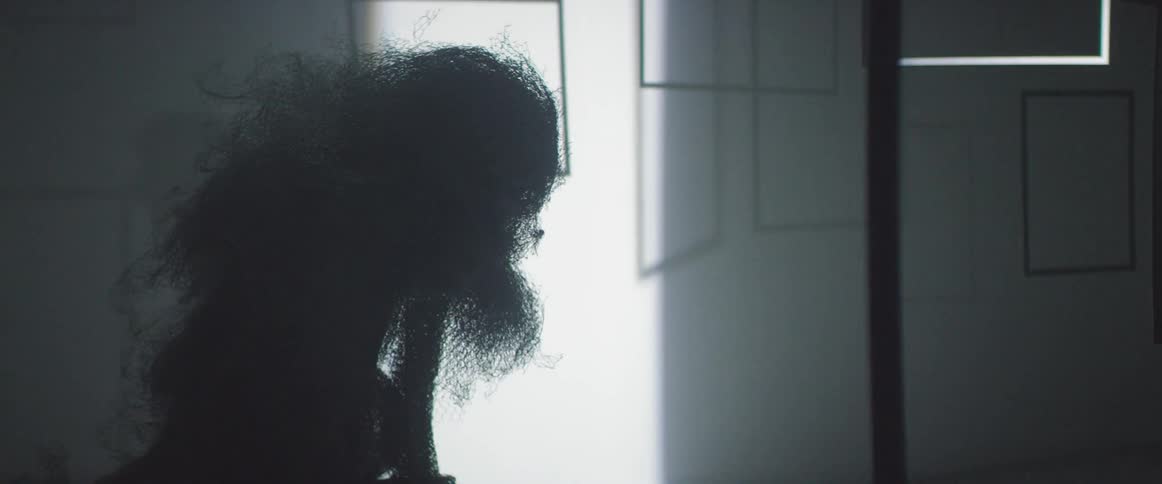 Light moves across a room highlighting a monkey sculpture