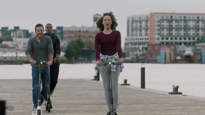 People riding scooters on a pier