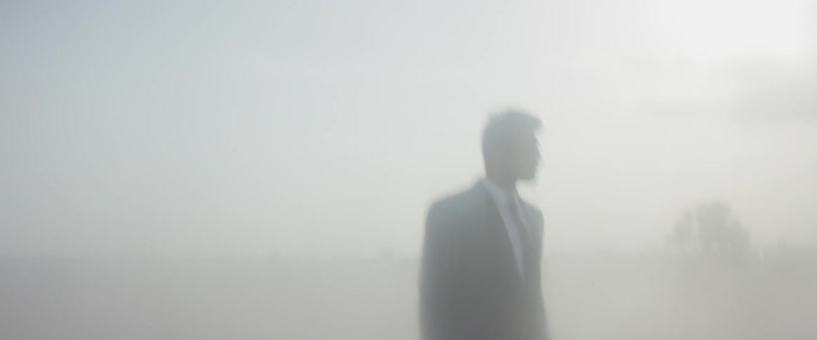 Man is a suit surrounded by the haze of sunlight
