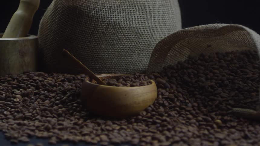 Cloth sacks sit on a pile of coffee beans