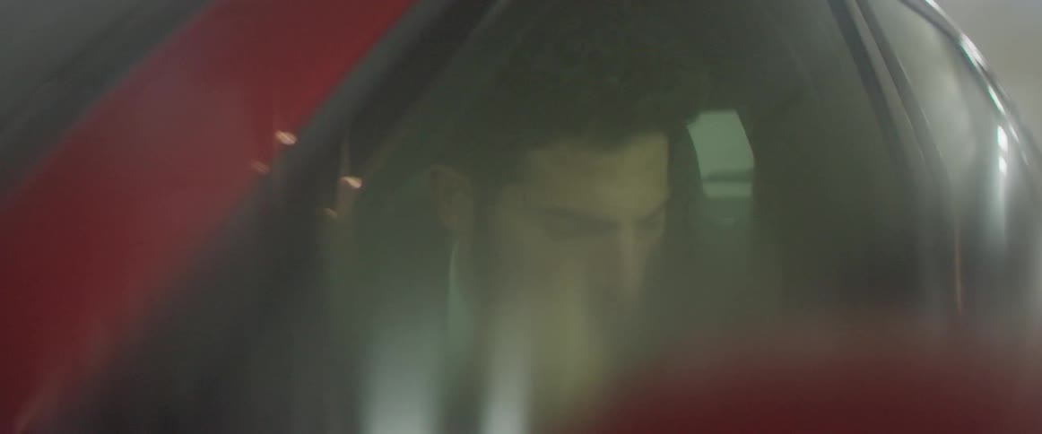 A man sitting in a car looks around