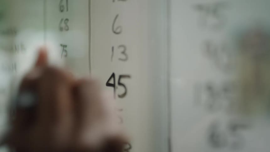 A man writes on a window with a marker