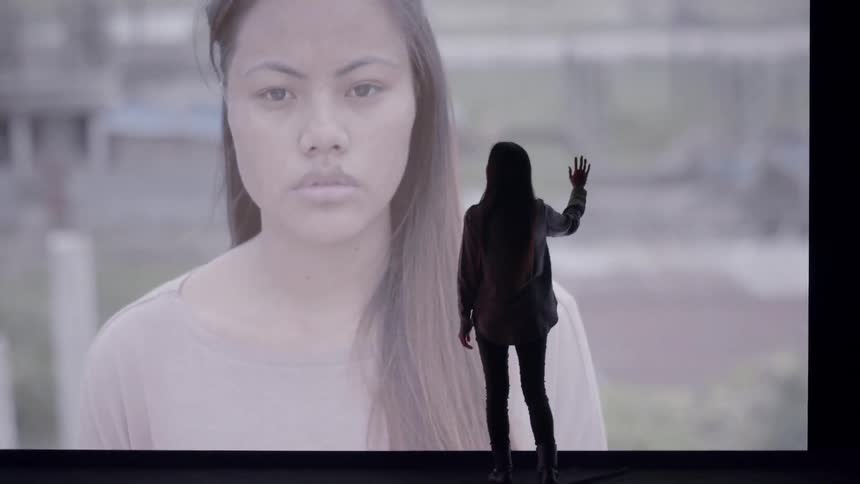 A woman reflects on images on LED wall