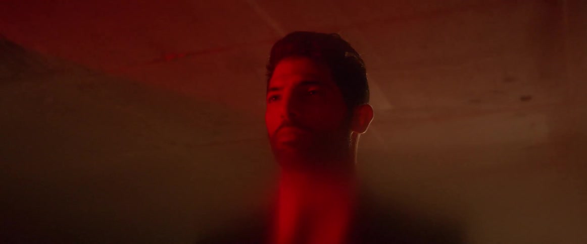 A man stands in a red lit room