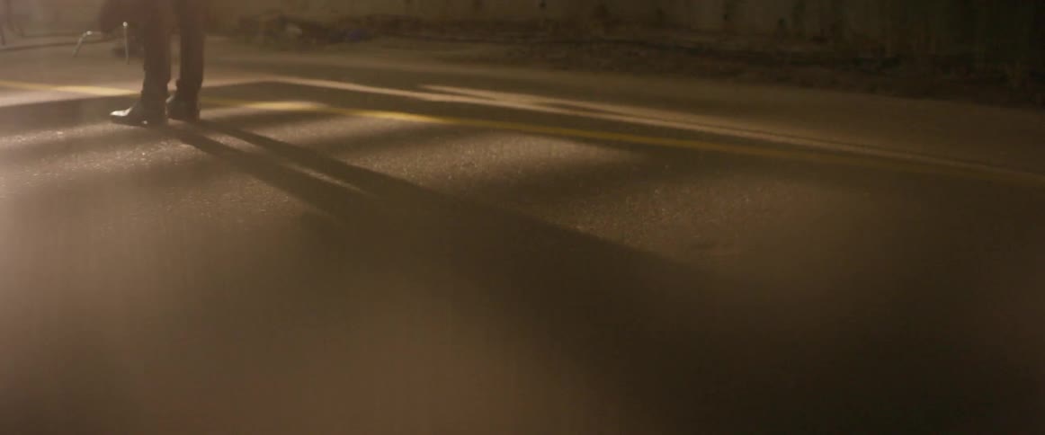 A person stands in the street at night